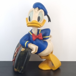 Donald Duck relaxing on his suitcase statue