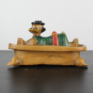 Vintage wooden statue of Scrooge McDuck bathing in money