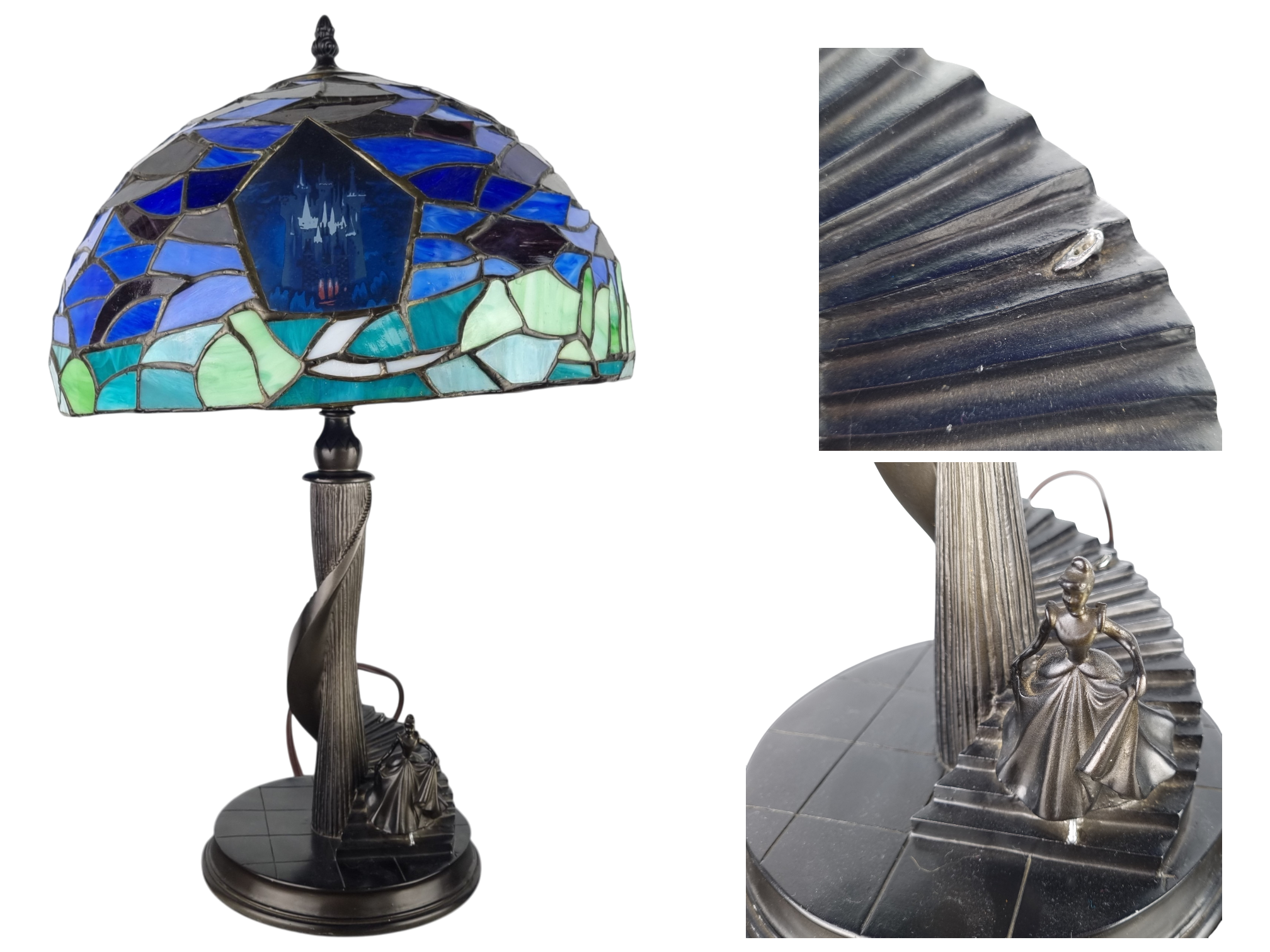 Decorative table lamp with a colorful stained-glass shade depicting a blue castle, on a dark metal pedestal base.