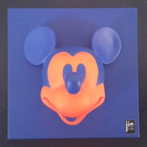 Blue product box with a 3D orange Mickey Mouse head model on the front and blue ears, branding logo at the bottom right corner