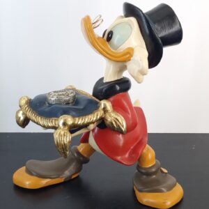 Scrooge McDuck with a lucky dime on a pillow statue